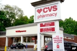 FILE: Vehicles are parked in front of a CVS Pharmacy in Mount Lebanon, Pa., on May 3, 2021.
