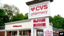 FILE: Vehicles are parked in front of a CVS Pharmacy in Mount Lebanon, Pa., on May 3, 2021.