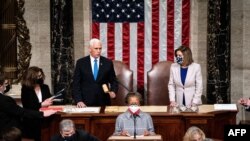 Vice-président Mike Pence (C) pene na démocrate Nancy Pelosi, mokambi ya ndako ya bokeli mibeko, na Congrès, na Capitole, Washington, DC, 7 janvier 2021.