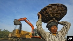 A laborer carries a basket filled with coal at a railway yard in the northern Indian city of Chandigarh, India, January 2011. (file photo)