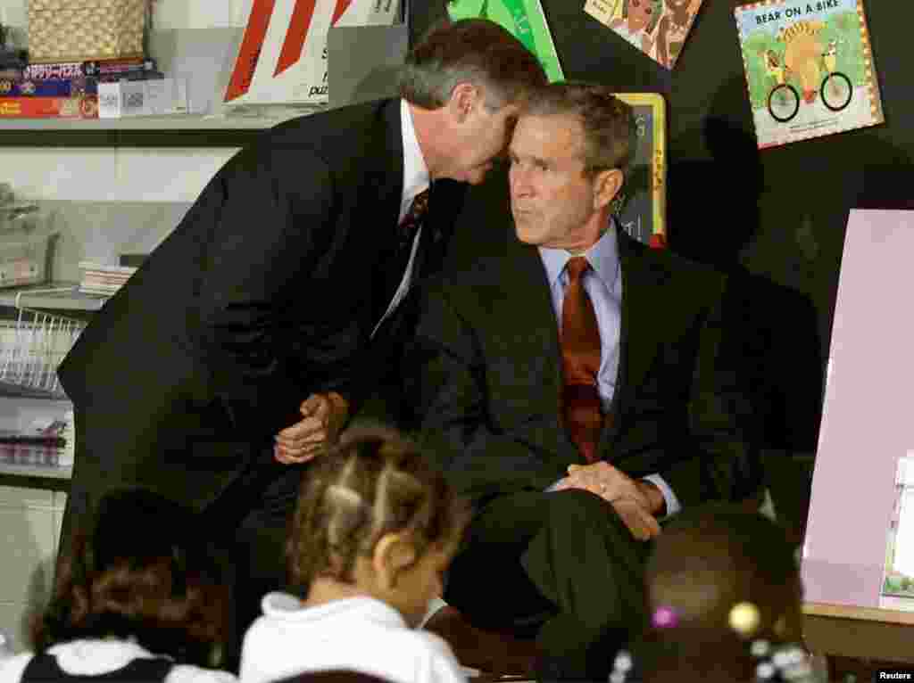 U.S. President George W. Bush listens as White House Chief of Staff Andrew Card informs him of a second plane hitting the World Trade Center, while Bush was conducting a reading seminar at the Emma E. Booker Elementary School in Sarasota, Florida.