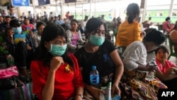 People wear face masks as a preventive measure against the COVID-19 coronavirus while waiting for a ride at the central railway station in Yangon on March 19, 2020. (Photo by Ye Aung THU / AFP)