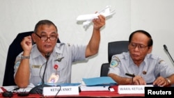 Tatang Kurniadi, left, chief of the National Transportation Safety Committee (NTSC), holds a model plane during a news conference in Jakarta, Jan. 29, 2015. 