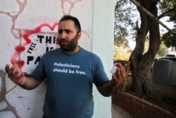 FILE - Palestinian activist Issa Amro, center, speaks after his release from detention, in the West Bank city of Hebron, Sept. 10, 2017.