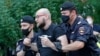 FILE - Police officers detain Alexander Chernykh, Kommersant newspaper journalist, during a rally to support Ivan Safronov near the Lefortovo prison in Moscow, Russia, July 13, 2020.