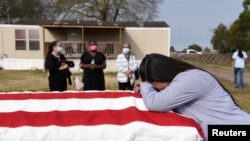 ຍານາງລີລາ ແບລງສ໌ ກົ້ມໄວ້ອາໄລສາມີ ທ່ານເກຣກກໍຣີ ແບລງສ໌ ອາຍຸ 50 ປີ ທີ່ເສຍຊີວິດຍ້ອນພະບາດໄວຣັສໂຄໂຣນາ
(ໂຄວິດ-19) ທີ່ເມືອງແຊນ ຟິລິບ ລັດເທັກຊັສ ເມື່ອວັນທີ 26 ມັງກອນ 2021. 