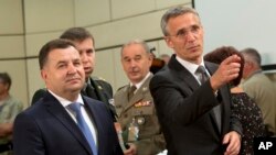 NATO Secretary-General Jens Stoltenberg, right, and Ukraine's Defense Minister Stepan Poltorak, left, arrive for a meeting of the NATO-Ukraine Commission at NATO headquarters in Brussels, June 25, 2015. 