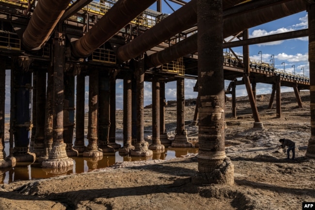 Calcified salt formations are pictured at the base of the pillars holding a disabled pumping station near Kibbutz Ein Gedi in eastern Israel on December 30, 2024. The station stopped operations due to the lake's drying. (Photo by Menahem Kahana / AFP)