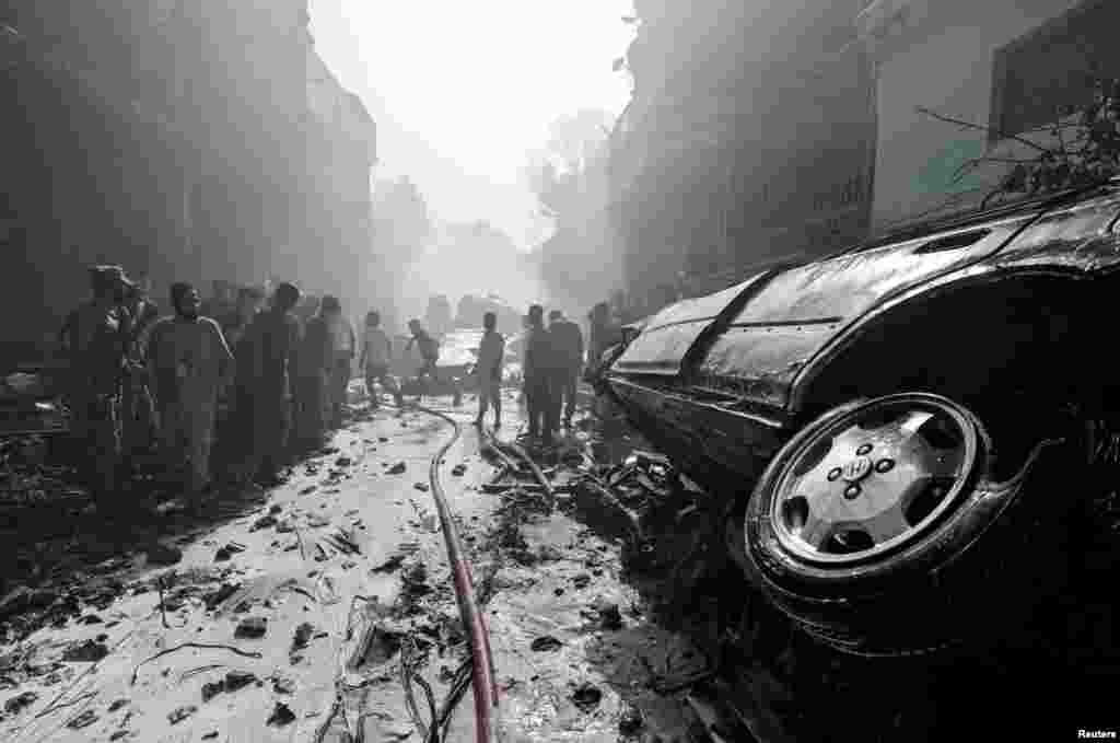 Rescue workers gather at the site of a passenger plane crash in a residential area near an airport in Karachi, Pakistan.