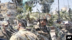 Syrian army soldiers, are seen through a damaged military truck window which was attacked by a roadside bomb, in Daraa city, southern Syria. The explosion targeted the Syrian military truck just seconds after a team of U.N. observers passed by.