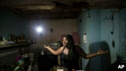 Dugleidi Salcedo complains to a neighbor about the high price of food as she prepares arepas for her three sons in her kitchen in the Petare slum, in Caracas, Feb. 14, 2019.