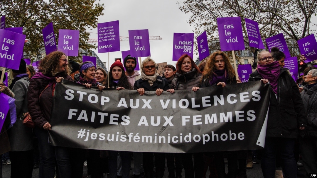 French actress Muriel Robin, center, marches with participants holding a banner that reads "Stop violence toward women" as they take part in a demonstration in Paris, Nov. 24, 2018. 
