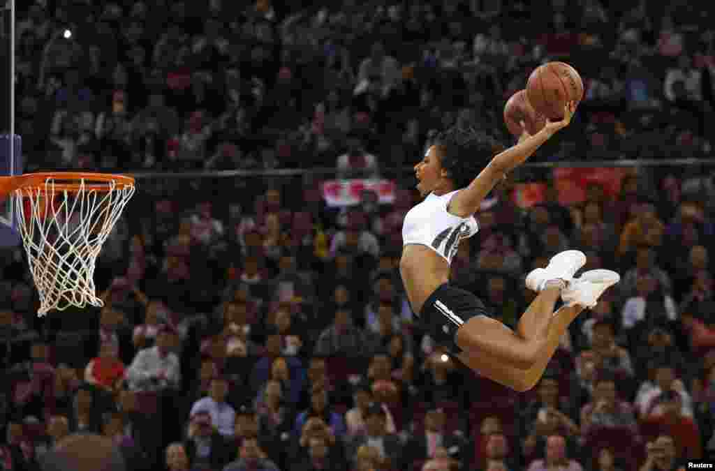 Seorang atlet perempuan tampak melakukan atraksi &quot;slam dunk&quot; sebelum pertandingan NBA antara&nbsp;Sacramento Kings dan Brooklyn Nets di Beijing, China. 