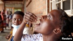 FILE - Eliza Tangwe, 18, takes a dose of oral cholera vaccine at a health center in response to a cholera outbreak in Blantyre, Malawi, November 16, 2022. 