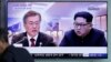 People watch a TV screen showing file footage of South Korean President Moon Jae-in and North Korean leader Kim Jong Un during a news program ahead of the inter-Korean summit at the Seoul Railway Station in Seoul, South Korea, April 26, 2018. 