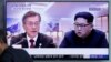 People watch a TV screen showing file footage of South Korean President Moon Jae-in and North Korean leader Kim Jong Un during a news program ahead of the inter-Korean summit at the Seoul Railway Station in Seoul, South Korea, April 26, 2018. 