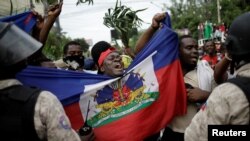 Manifestan nan Pòtoprens kap pwoteste devan yon kòdon sekirite polis nan Petyon Vil, Ayiti, 20 oktòb 2019. Foto: REUTERS/Andres Ma