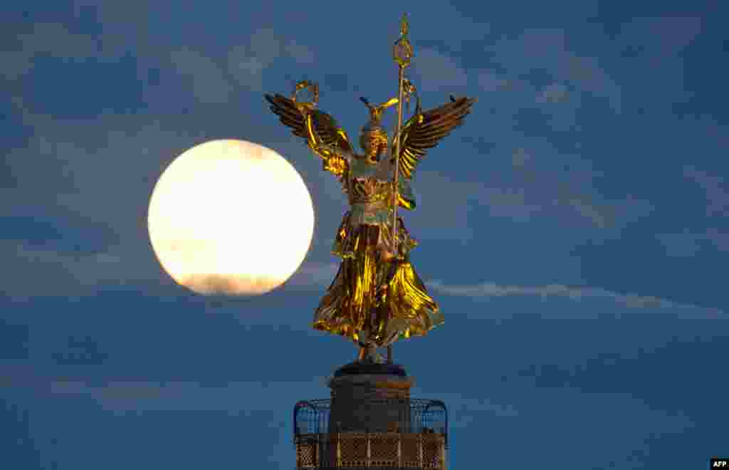 The full moon behind the victory column in Berlin, Germany