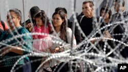 Para migran Amerika Tengah di kota Tijuana, Meksiko antri untuk berusaha memasuki wilayah AS di pos penyeberangan San Ysidro, San Diego.