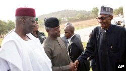 Muhammadu Buhari (à droite) accueilli par son vice-président Yemi Osinbajo (au centre) à son retour à Abuja, après une absence d'un mois et demi, le 10 mars 2017.