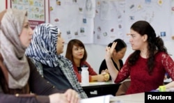 FILE - Migrants attend a lesson at the "institute for intercultural communication" in Berlin, Germany, April 13, 2016.