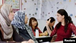 FILE - Migrants attend a lesson at the "institute for intercultural communication" in Berlin, Germany, April 13, 2016.