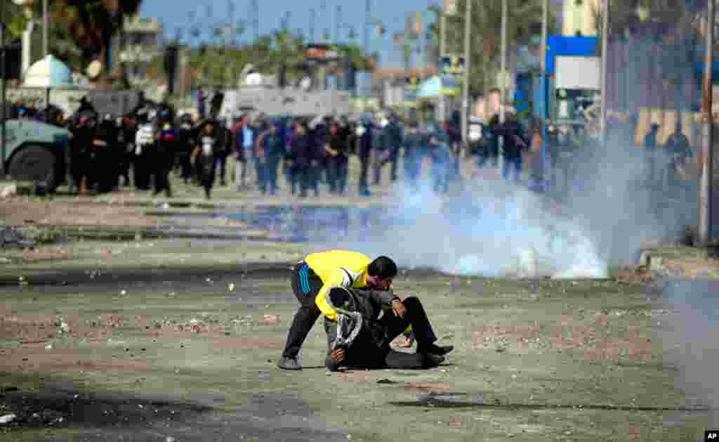 An Egyptian protester evacuates a wounded man in Port Said, Egypt, March 6, 2013.