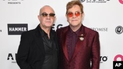 Elton John, right, and Bernie Taupin arrive at a celebration of Elton John's 70th birthday and 50-year songwriting partnership with Taupin on March 25, 2017 in Los Angeles. 