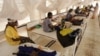 FILE - Women and their babies suffering from malnutrition sit on beds at a make shift hospital in Maradi, Niger, July 30, 2005. 