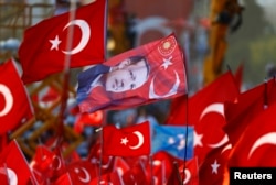 FILE - A flag with the picture of Turkey's President Tayyip Erdogan is featured during the Democracy and Martyrs Rally, organized by Erdogan and the ruling AK Party in Istanbul, Aug. 7, 2016.