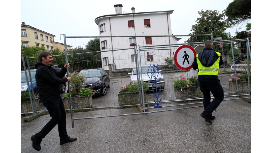 Petugas menyingkirkan pagar pembatas di alun-alun Uni Eropa, di Nova Gorica, Slovenia, perbatasan Slovenia dan Italia, di tengah pandemi Covid-19, 15 Juni 2020.