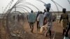 A file photo taken Jan. 19, 2016 shows displaced people next to a razor wire fence at the United Nations base in the capital Juba, South Sudan. 