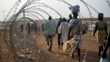 A file photo taken Jan. 19, 2016 shows displaced people next to a razor wire fence at the United Nations base in the capital Juba, South Sudan. 