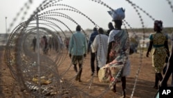 A file photo taken Jan. 19, 2016 shows displaced people next to a razor wire fence at the United Nations base in the capital Juba, South Sudan. 