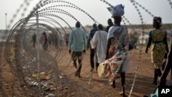 Para pengungsi berjalan di sepanjang pagar kawat berduri dekat markas PBB di ibukota Juba, Sudan Selatan (Foto: dok).