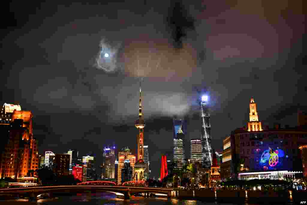 La luna llena se eleva sobre los rascacielos del distrito financiero de Lujiazui en Shanghái el 18 de septiembre de 2024. &nbsp;