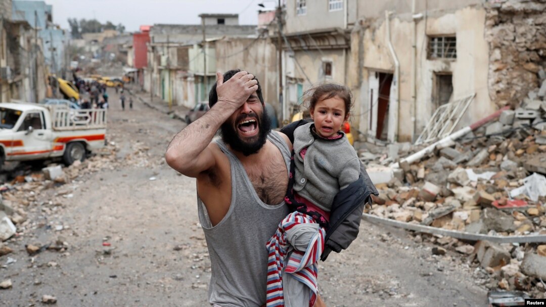 Seorang pria menangis saat ia membawa putrinya dan berjalan dari bagian yang dikuasai Islamic State di Mosul menuju ke arah pasukan khusus Irak selama pertempuran di Mosul, Irak, 4 Maret 2017 (foto: REUTERS/Goran Tomasevic)