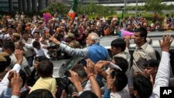 Opposition Bharatiya Janata Party (BJP) leader and India's next prime minister Narendra Modi greets the crowd standing on the footboard of his SUV outside the New Delhi airport, India, May 17, 2014.