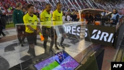 L'arbitre brésilien Wilton Pereira Sampaio (C) et ses assistants passent devant un écran de l'assistance vidéo à l'arbitrage (VAR) au stade Monumental de Buenos Aires, le 25 octobre 2017.