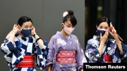 زنان ژاپنی در لباس‌های سنتی و با ماسک صورت بیرون از استادیوم ملی ورزشی، محل اصلی برگزاری بازی‌های المپیک ۲۰۲۰ - ۱۲ مرداد ۱۴۰۰