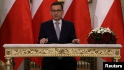 Newly appointed Polish Prime Minister Mateusz Morawiecki reacts after receiving his nomination from President Andrzej Duda during a government swearing-in ceremony in Warsaw, Poland, Dec. 11, 2017.