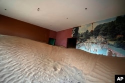 Sand is piled in a house at the Bedouin village of al-Ghuraifabout 100 km, 62 miles, southeast of Sharjah, United Arab Emirates, Sunday, July 9, 2023. (AP Photo/Kamran Jebreili)