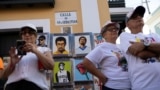 Personas observan retratos pintados a mano de Bad Bunny y Roberto Clemente que están a la venta, durante la inauguración de la 55a edición del Festival Anual de la Calle San Sebastián en el Viejo San Juan, Puerto Rico, el 16 de enero de 2025.