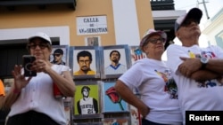 Personas observan retratos pintados a mano de Bad Bunny y Roberto Clemente que están a la venta, durante la inauguración de la 55a edición del Festival Anual de la Calle San Sebastián en el Viejo San Juan, Puerto Rico, el 16 de enero de 2025.