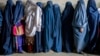 FILE - Afghan women wait for food distributed by a humanitarian aid group, in Kabul, Afghanistan, May 23, 2023. U.S. Secretary of State Antony Blinken has announced new programs to empower Afghan women in Afghanistan. 