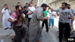Free Syrian Army members push along a man suspected of working for the Assad regime. (Photo courtesy Bunyamin Aygun)