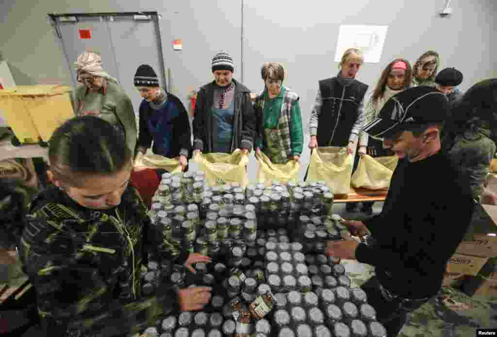 Workers from Rinat Akhmetov&#39;s Foundation sort humanitarian aid for distribution at the Donbass Arena stadium in Donetsk, Feb. 3, 2015.