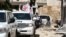 Vehicles of the International Committee of the Red Cross and the United Nations wait on a street after an aid convoy entered the rebel-held Syrian town of Daraya, southwest of the capital Damascus, June 1, 2016.
