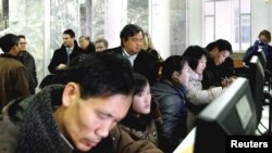 Former New Mexico Governor Bill Richardson (C, back row) looks at North Koreans working on computers at the Grand People's Study House in Pyongyang, January 9, 2013 in this picture released by the North Korea's KCNA news agency. 