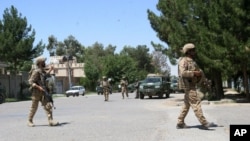 FILE - Afghanistan, security forces take position during a fighting outside a government compound in the city of Lashkar Gah, capital of Helmand province, Afghanistan, May. 13, 2015. 